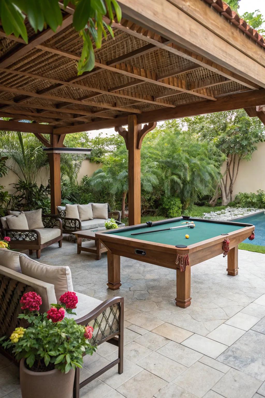 A snug pool table arrangement beneath a timber trellis, accompanied by seating and greenery.